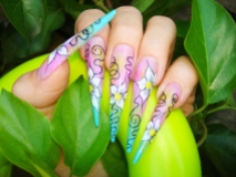 closeup of colorful stiletto nails with floral free hand drawn pattern